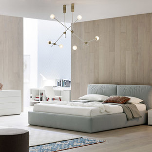 Ejemplo de dormitorio principal, minimalista, grande, sin chimenea, con paredes blancas, suelo de madera clara, suelo marrón y marco de chimenea de hormigón