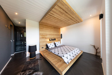 Geräumiges Shabby-Style Schlafzimmer im Loft-Style mit weißer Wandfarbe, Betonboden und schwarzem Boden in Frankfurt am Main