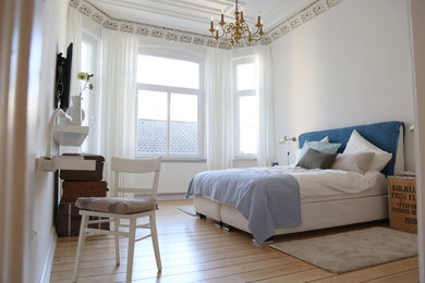 Mittelgroßes Shabby-Style Schlafzimmer mit weißer Wandfarbe und hellem Holzboden in Bremen