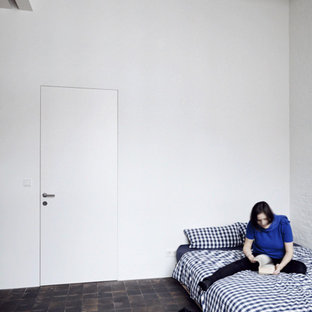 Diseño de dormitorio urbano con paredes blancas, suelo de ladrillo y suelo rojo
