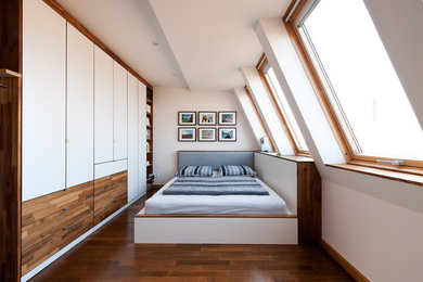Mittelgroßes Modernes Schlafzimmer im Dachboden ohne Kamin mit weißer Wandfarbe und braunem Holzboden in Sonstige
