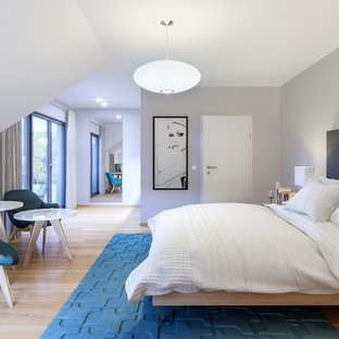 Großes Modernes Hauptschlafzimmer ohne Kamin mit grauer Wandfarbe, hellem Holzboden und beigem Boden in Frankfurt am Main