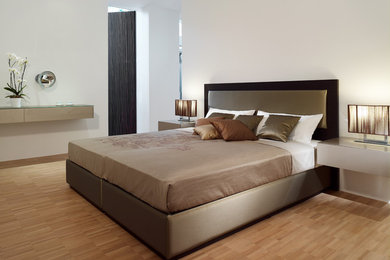 Großes Modernes Hauptschlafzimmer ohne Kamin mit weißer Wandfarbe und braunem Holzboden in Düsseldorf