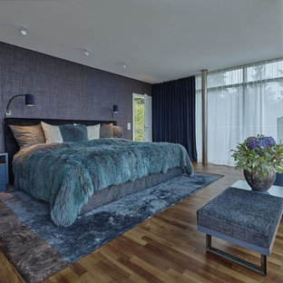 Großes Modernes Hauptschlafzimmer ohne Kamin mit blauer Wandfarbe, braunem Holzboden und braunem Boden in Berlin