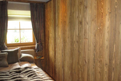 Mittelgroßes Landhaus Hauptschlafzimmer ohne Kamin mit brauner Wandfarbe, Betonboden und braunem Boden in München
