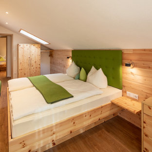 Mittelgroßes Landhaus Hauptschlafzimmer mit weißer Wandfarbe, braunem Holzboden und braunem Boden in Sonstige