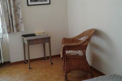 他の地域にある小さなトラディショナルスタイルのおしゃれな客用寝室 (黄色い壁、無垢フローリング) のインテリア