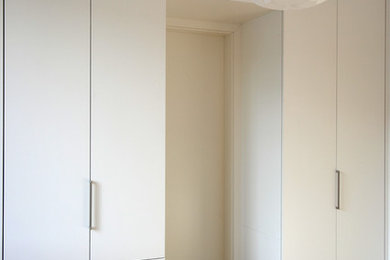 Geräumiges Modernes Schlafzimmer mit braunem Holzboden, weißer Wandfarbe und braunem Boden in Berlin