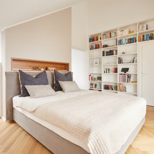 Modernes Hauptschlafzimmer ohne Kamin mit weißer Wandfarbe, hellem Holzboden und gewölbter Decke in München
