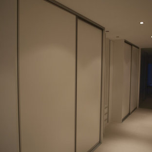 Imagen de dormitorio principal, contemporáneo, pequeño, con paredes blancas, moqueta, chimenea de doble cara y suelo blanco