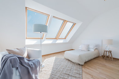 Ejemplo de dormitorio contemporáneo con paredes blancas, suelo de madera clara y suelo beige