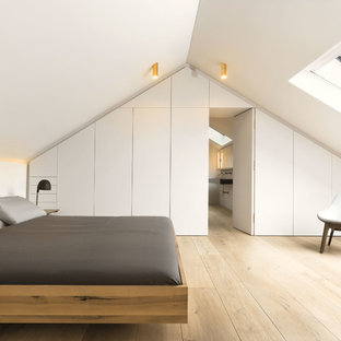 Mittelgroßes Nordisches Hauptschlafzimmer ohne Kamin mit weißer Wandfarbe, hellem Holzboden und beigem Boden in München