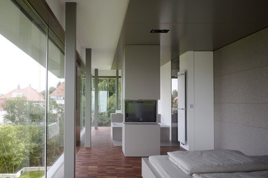 Großes Modernes Hauptschlafzimmer mit grauer Wandfarbe, dunklem Holzboden und braunem Boden in Sonstige