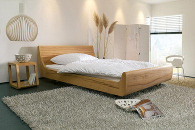 Modelo de habitación de invitados contemporánea de tamaño medio sin chimenea con paredes blancas, suelo gris y suelo vinílico
