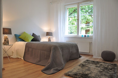 Mittelgroßes Klassisches Schlafzimmer ohne Kamin mit weißer Wandfarbe und hellem Holzboden in Berlin