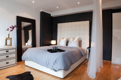 Mittelgroßes Modernes Schlafzimmer mit bunten Wänden, braunem Holzboden und braunem Boden in Berlin