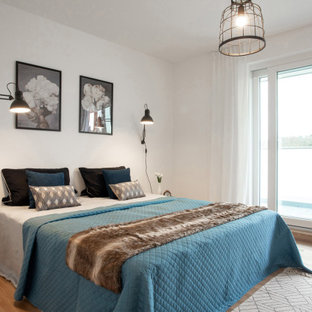 Modernes Schlafzimmer mit weißer Wandfarbe, braunem Holzboden und braunem Boden in Köln