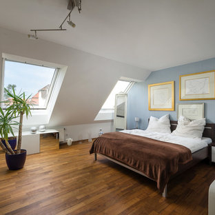 Großes Modernes Hauptschlafzimmer ohne Kamin mit blauer Wandfarbe, dunklem Holzboden und braunem Boden in München