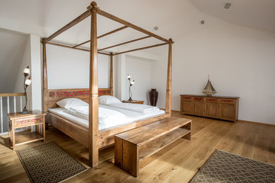 Ejemplo de dormitorio principal nórdico grande sin chimenea con paredes blancas y suelo de madera clara