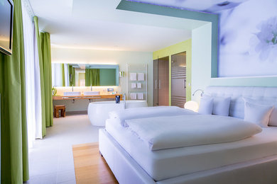 Geräumiges Modernes Hauptschlafzimmer ohne Kamin mit bunten Wänden und braunem Holzboden in Stuttgart