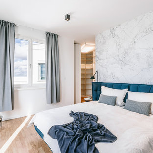 Modernes Gästezimmer ohne Kamin mit weißer Wandfarbe, hellem Holzboden und beigem Boden in Berlin