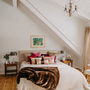 Klassisches Schlafzimmer mit weißer Wandfarbe, braunem Holzboden und braunem Boden in München