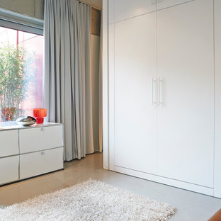 Geräumiges Industrial Schlafzimmer im Loft-Style mit grauer Wandfarbe, Betonboden und grauem Boden in Berlin