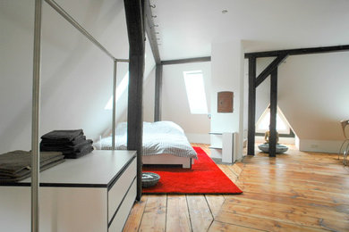 Diseño de dormitorio principal rural grande sin chimenea con paredes blancas, suelo de madera oscura y suelo marrón