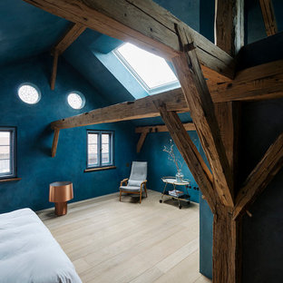 Großes Uriges Hauptschlafzimmer ohne Kamin mit blauer Wandfarbe, hellem Holzboden und beigem Boden in München