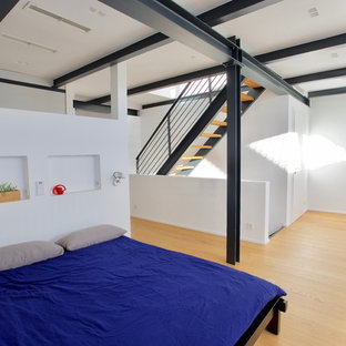 Foto de dormitorio tipo loft, moderno, grande, con paredes blancas, suelo de madera clara y suelo amarillo
