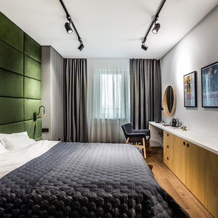 Modernes Hauptschlafzimmer mit braunem Holzboden, grauer Wandfarbe und braunem Boden in Berlin