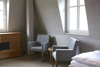 Imagen de habitación de invitados contemporánea de tamaño medio con paredes grises, suelo de baldosas de cerámica y suelo gris