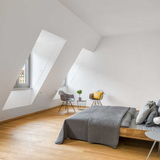 Modernes Schlafzimmer mit weißer Wandfarbe, braunem Holzboden und braunem Boden in Dresden