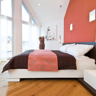 Großes Modernes Hauptschlafzimmer mit roter Wandfarbe, braunem Holzboden und braunem Boden in Berlin