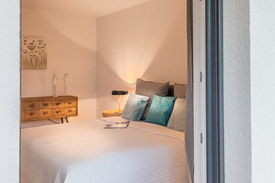Kleines Skandinavisches Schlafzimmer ohne Kamin mit weißer Wandfarbe, braunem Holzboden und braunem Boden in Bonn
