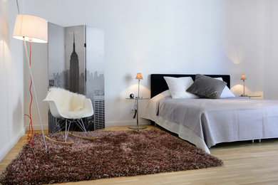 Mittelgroßes Nordisches Schlafzimmer ohne Kamin mit weißer Wandfarbe und hellem Holzboden in Berlin