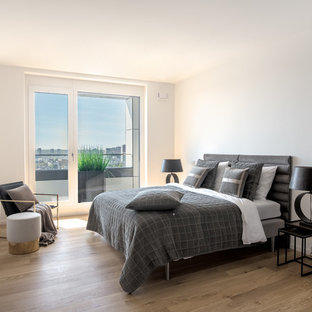 Modernes Hauptschlafzimmer ohne Kamin mit weißer Wandfarbe, braunem Holzboden und braunem Boden in Frankfurt am Main