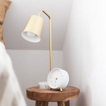 Skandinavisches Schlafzimmer: goldene Nachttischlampe auf Hocker
