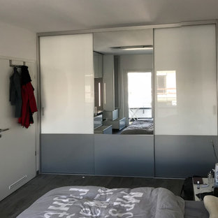 Ejemplo de dormitorio principal, moderno, de tamaño medio, sin chimenea, con paredes blancas, suelo de pizarra y suelo gris