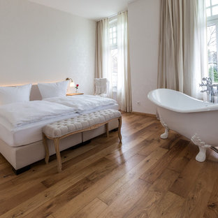 Mittelgroßes Klassisches Hauptschlafzimmer ohne Kamin mit weißer Wandfarbe, braunem Holzboden und braunem Boden