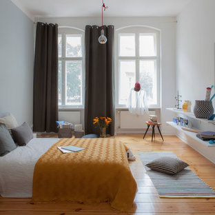 Foto di una grande camera matrimoniale scandinava con pareti bianche, pavimento in legno massello medio, nessun camino e pavimento marrone