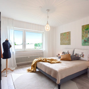 Modernes Schlafzimmer mit weißer Wandfarbe, braunem Holzboden und grauem Boden in Köln