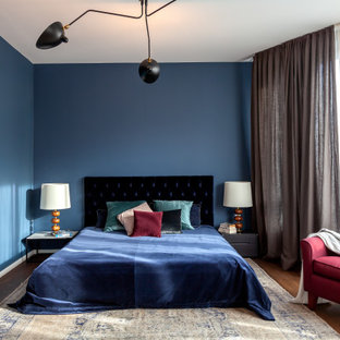 Mittelgroßes Modernes Hauptschlafzimmer mit blauer Wandfarbe und braunem Boden in Berlin