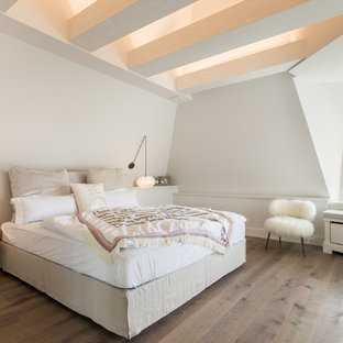 Landhausstil Schlafzimmer mit weißer Wandfarbe, dunklem Holzboden und braunem Boden in Sonstige
