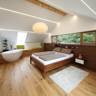 Großes Modernes Gästezimmer mit weißer Wandfarbe, hellem Holzboden und beigem Boden in München