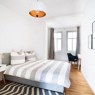 Mittelgroßes Nordisches Gästezimmer ohne Kamin mit weißer Wandfarbe, braunem Holzboden und braunem Boden in Berlin