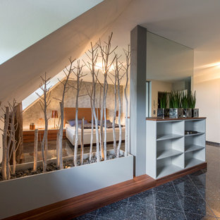 Modelo de dormitorio tipo loft, actual, grande, sin chimenea, con paredes blancas y suelo negro