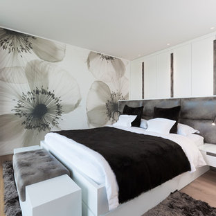 Mittelgroßes Modernes Hauptschlafzimmer ohne Kamin mit weißer Wandfarbe, braunem Holzboden und braunem Boden in Köln