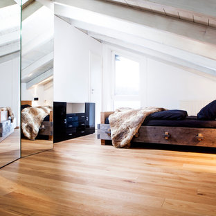 Imagen de dormitorio principal, nórdico, de tamaño medio, sin chimenea, con paredes blancas, suelo de madera clara, marco de chimenea de metal y suelo marrón
