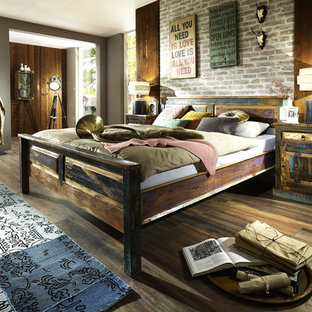 Großes Industrial Hauptschlafzimmer ohne Kamin mit bunten Wänden, dunklem Holzboden und braunem Boden in Düsseldorf